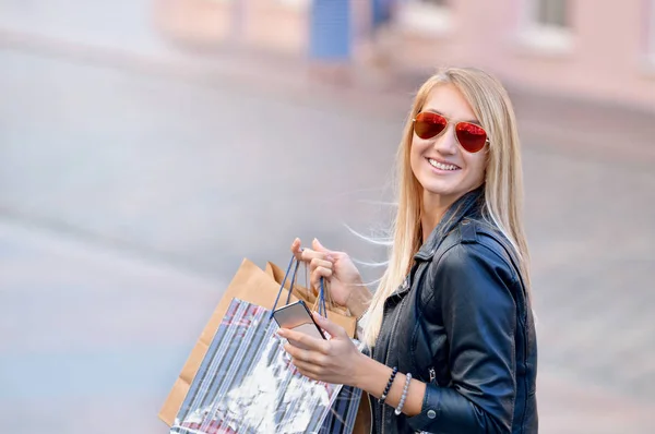 Retrato joven encantadora mujer de pelo largo sosteniendo bolsas de compras —  Fotos de Stock