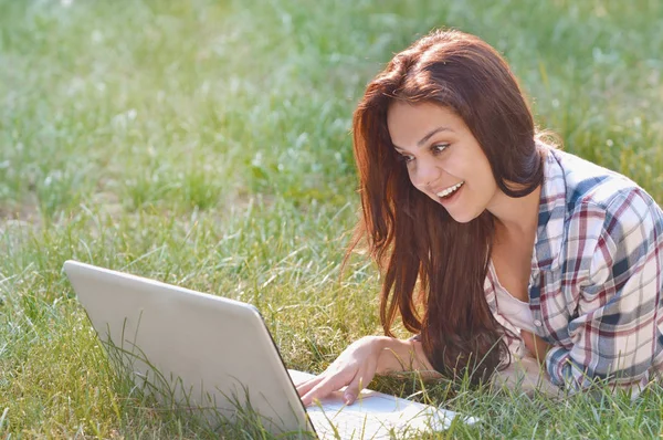 Dziewczyna Student praca na laptopie, leżąc na trawie w parku — Zdjęcie stockowe