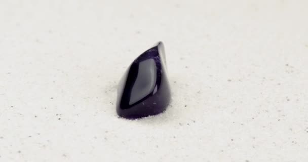 白い砂の上を回転させる紫のアメジスト — ストック動画