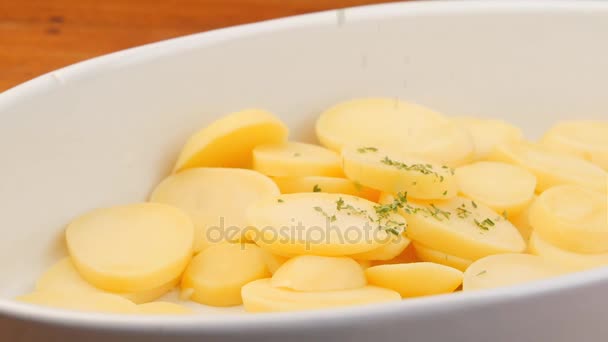 Seasoning potato slices dish in slow motion — Stock Video