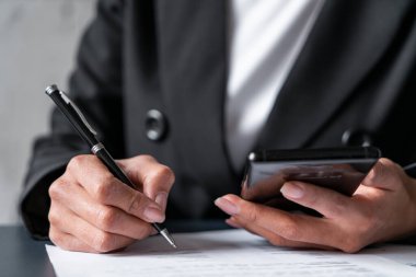 Akıllı telefon ve kalemle kadın eli