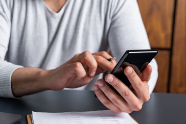 Adam iş saatlerinde akıllı telefon kullanıyor. Hücresel bağımlılık kavramı.