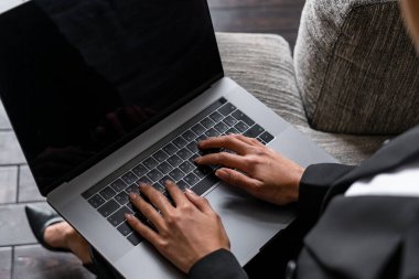 Koltukta dizüstü bilgisayarda daktilo eden iş kadını
