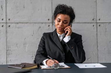 Telefondaki Afrikalı iş kadını not alıyor