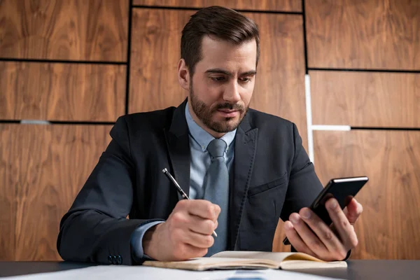 Ein gutaussehender Mann im Anzug macht sich Notizen. Erfolgskonzept. Formales Tragen. — Stockfoto