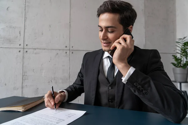 Lächelnder Geschäftsmann bei Vertragsunterzeichnung am Telefon — Stockfoto