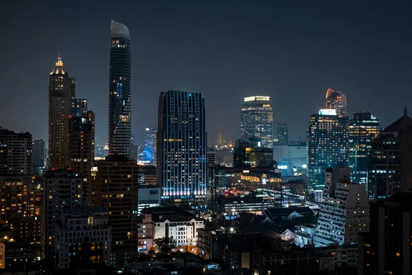 Gece vakti Bangkok siluetinin panoramik görüntüsü. Tayland 'ın aydınlatılmış şehir merkezi. Çağdaş binaların dış yüzeyi camdan.. — Stok fotoğraf