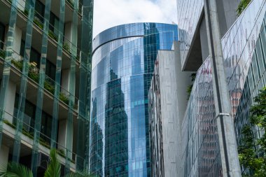 Gündüz vakti Singapur şehrinin resimli gökdelenlerinin alçak açılı görüntüsü. Finansal bölge ve Asya bölgesindeki ticaret merkezi. Başarı kavramı. Yüksek teknoloji dünyasındaki modern binalar.