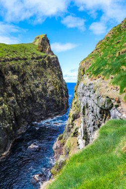 Dalgalar Mykines Adası 'nın kayalıkları arasında çarpışıyor.