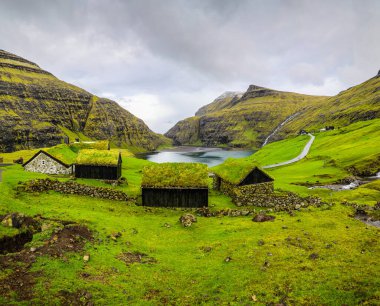 Faroe Adaları 'ndaki Saksun' un büyüleyici yeşil çim evlerinin panoramik manzarası