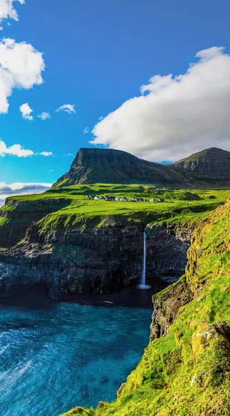 View of Gasadalur waterfall cascading into the sea