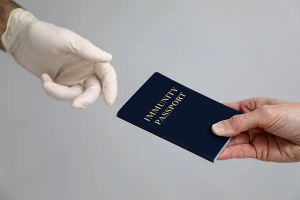 Mock up of an immunity passport being presented to a gloved hand
