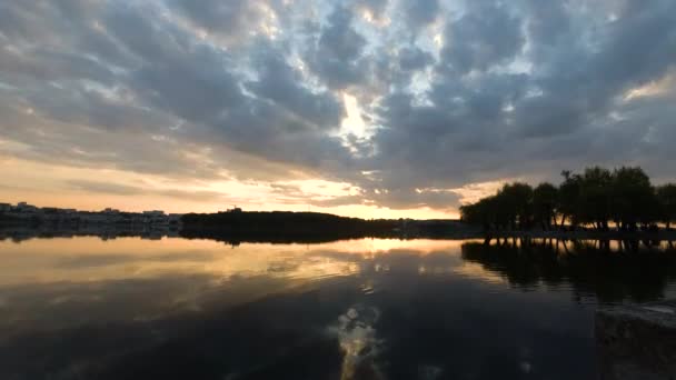 A naplemente időpontja az erdő mögött a tó közelében tavasszal — Stock videók