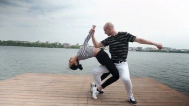 Birbirine aşık çift göl kıyısında dans edip dans ediyorlar.