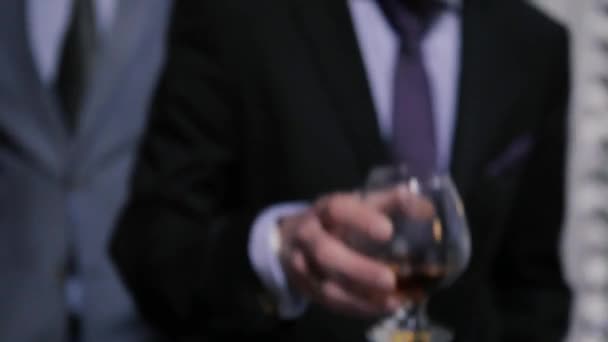 一个男人用右手端着一杯白兰地在餐馆里转来转去 — 图库视频影像