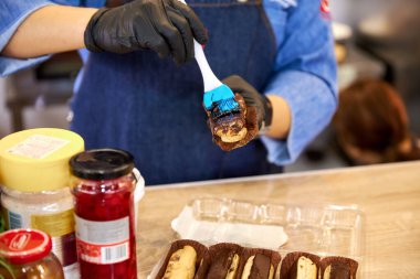 Aşçı pasta üzerine çikolata kreması sürer.