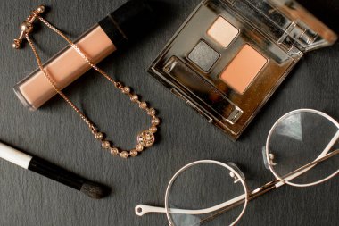 Mavi arka planda kadın kozmetik ürünleri ve aksesuarları