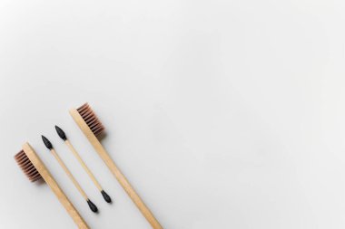 Beyaz arka planda biyolojik olarak çözünebilir kulak çubukları ve diş fırçaları.