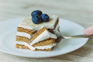 Çatallı bir çay tabağında yabanmersinli bal keki.