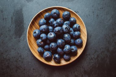 Böğürtlenler bir tabakta koyu bir arka planda