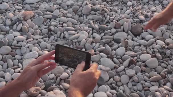 在土耳其安塔利亚市Cirali海滩的海龟保护区 人类的手帮助海龟爬上石头砸向大海 人们在智能电话中拍照或录像小海龟到海洋的路径 海洋动物的自然本能 — 图库视频影像