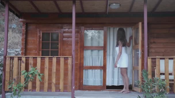 Lächelndes Mädchen Steht Auf Der Veranda Und Blickt Verschiedene Richtungen — Stockvideo