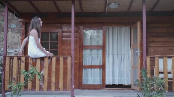 Lächelnde Junge Frau Steht Auf Der Veranda Und Klettert Auf — Stockvideo