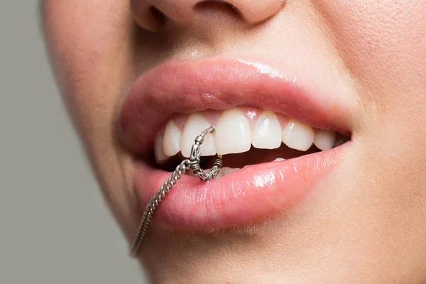Piercing zblízka v ústech mladé dívky s plné rty, bílé zuby s přírodní make-up. Sexy, piercing v zubech — Stock fotografie