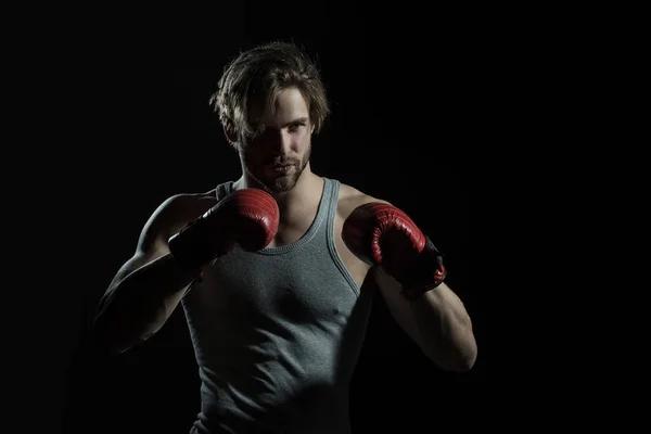 Man in red boxing gloves on a black background. Attractive sports guy boxing — Stock Photo, Image
