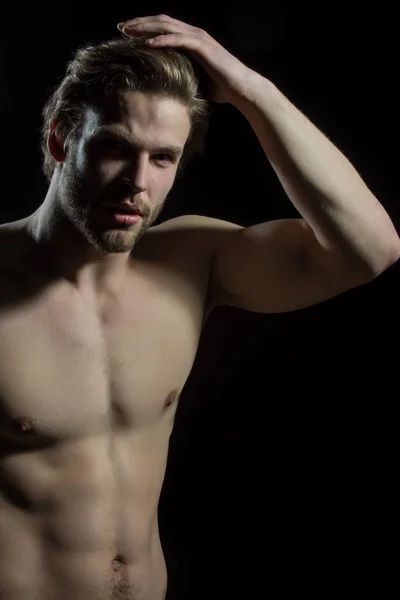 Ελκυστική γυμνός άντρας αγγίζει τα μαλλιά του. Όμορφος άντρας με ένα όμορφο σώμα για το studio σε μαύρο φόντο — Φωτογραφία Αρχείου