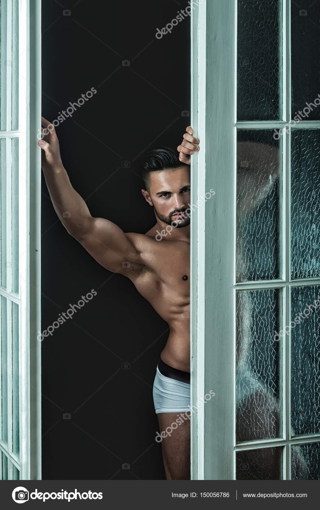 Man In White Shorts Stands Near The Door And Looking At The