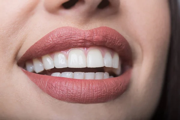 Glimlach op vrouwelijke gezicht, weelderige lippen met matte lipstick, gezonde witte tanden, schone huid, lipvergroting, botox voor gezicht. Aantrekkelijk meisje, deel van gezicht. Jonge gelukkig vrouwelijke mond, geluk en plezier — Stockfoto