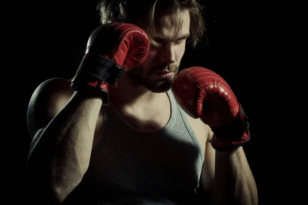Serious men in boxing gloves are practicing. Cool young man with boxing gloves. Attractive guy boxer closeup on black background — Stock Photo, Image