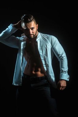 Siyah arka plan üzerine seksi iş adamı. Baştan çıkarıcı ve çeken adam. Esmer adam beyaz düğmeleri gömlek