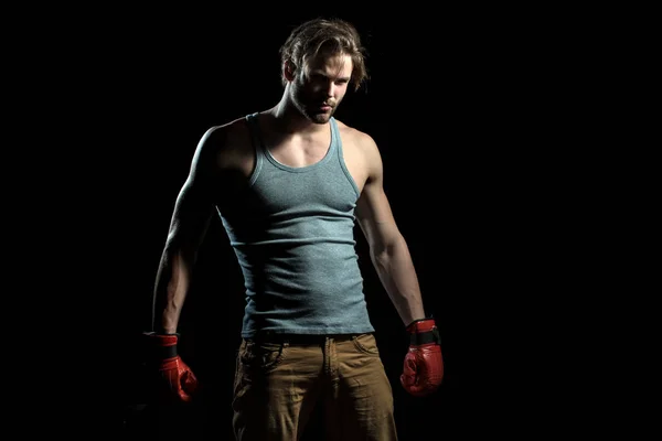 Un tipo serio con guantes de boxeo rojos. Hombre musculoso en camiseta gris se está preparando para la batalla. Boxeador en el ring. Atractivo chico deportista con guantes rojos — Foto de Stock