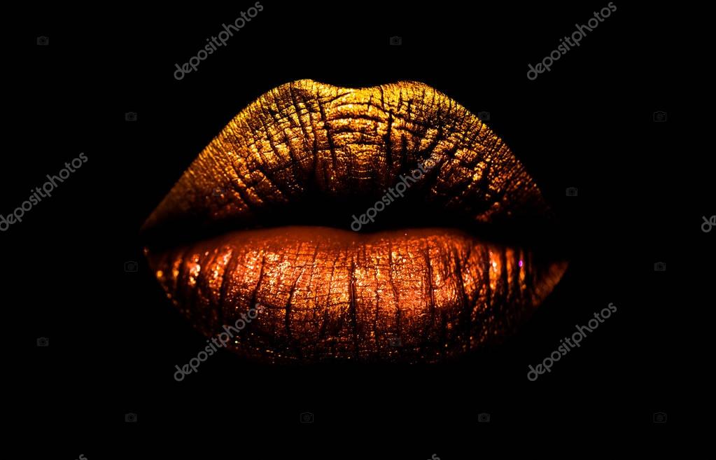 Golden brown lipstick on lips isolated on black background. Sexy lips, female mouth. Imprint lips. Luxury cosmetics for girls and women. Beautiful female lips. Female beauty concept girl