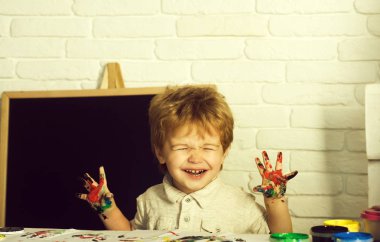 Komik mutlu çocuk mutluluktan gözleri kapalı ve ev okullaşma boya, okul ya da anaokulu, ana sayfa eğitim ve sanat, küçük sanatçı sevimli ellerini gösterdi. Mutlu çocukluk, çocuk neşeyle güler