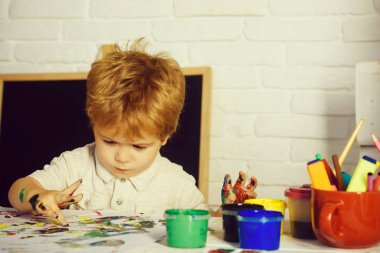 Resim Resim çocuk, sevimli çocuk cidden parmak ve boyalar kağıt, küçük sanatçı, yaratıcı eğitim, dersleri okul veya evde ilginç çizer. Parmak boyalar çocuklar için. Yeşil, mavi boya