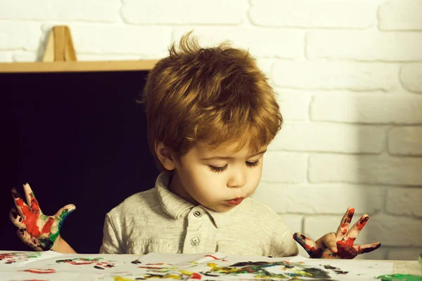 Şirin çocuk komik surat ile güzel çocuk boyama, parmak ilk fotoğraf sırasında boyar. Bebek yanakları, çocuk Okulu kursları, reklam, eğitim için sınıf, hobi öğrenmek için çocuk Merkezi ana