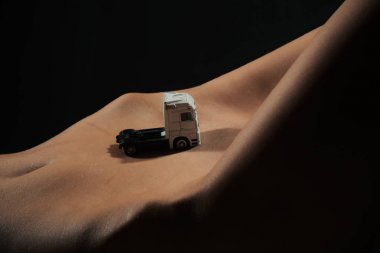 Kadın bedeninin kamyonda. Yük taşıma, sürücü kamyon şoförü. Kötü ve iyi yollar. Seksi taşıma, sürüş kadın. Çıplak pubis, kadın mide, oyuncak araba. Depilasyon kadın için. Kızın karnı üzerinde beyaz araba