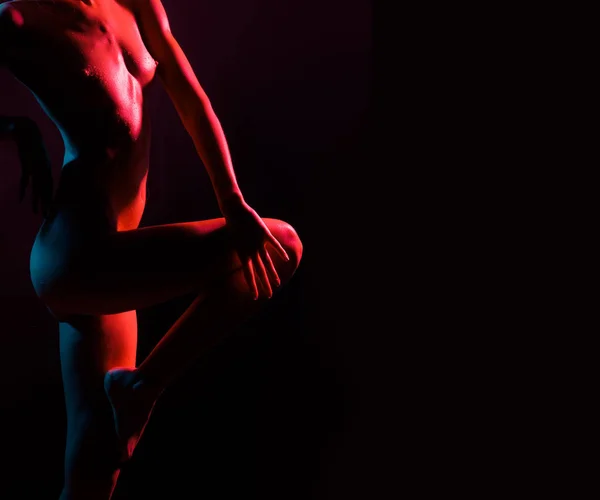 Pole Dancer female Stripper in Night Sensual Red light. Beautiful Girl with Sexy Body. Romantic Hot Erotic Private dance, striptease. Naked sexy girl holding her leg. Beautiful woman dance striptease