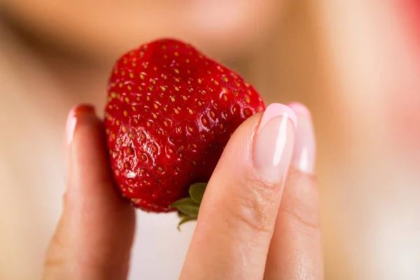 Fresa, manos femeninas sostienen la baya roja fresca. Símbolo sexy. Comida saludable, bayas y frutas para el desayuno. Cosecha de los campos de cultivo. Delicioso postre de salud. Chica con manicura sostiene fresa —  Fotos de Stock