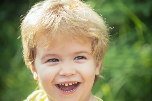 Muchacho feliz sonriendo retrato. Cara de niño con sonrisa. Feliz infancia. Chico alegre alegre divertido. Fondo de niños, jardín de infantes. Hermoso niño de 3 años. Retrato sobre fondo verde de la naturaleza —  Fotos de Stock