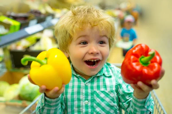 幸せな野菜の子。スーパー マーケットでかわいい子供は、サラダのためのブルガリアのピーマンを保持しています。健康食品、ランチに新鮮な野菜。ストアに台所および調理のための新鮮な食材をショッピングします。離乳食 — ストック写真