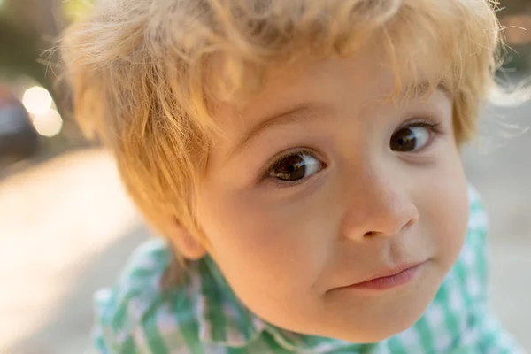 Cara divertida retrato niño de cerca. Cara de dulce niño lindo, chico mira a la cámara, expresión emotiva, ojos abiertos, niño interesado. Niño rubio de 3 años aprende sabe algo nuevo. Boy explora el mundo — Foto de Stock