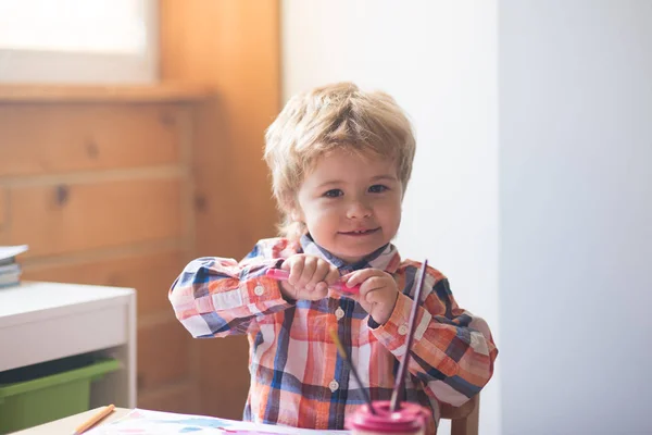 Kid dragningar rosa tuschpenna och akvarell färger. Glad lite konstnär målar en målning av ljusa färger, barnens konst, konstterapi. Begåvade förskolebarn målare — Stockfoto