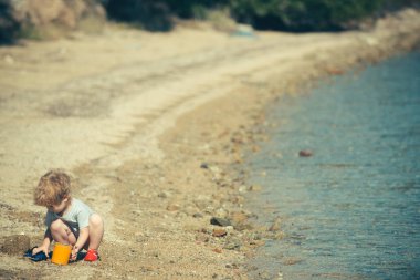 Yaz tatil tatil arka plan. Deniz gezisi. Sahil tatil çocuklu. Deniz ülkelerde Turizm. Zevk ve rahatlama bekletin. Küçük çocuk sahilde oynuyor