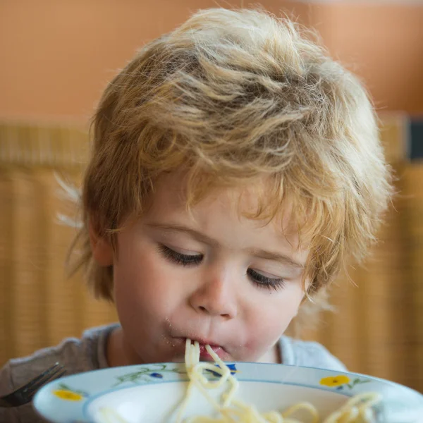 Aç çocuk büyük iştah ile öğle yemeği yiyor. Beslenme sağlıklı çocuklar için. Dengeli beslenme bol vitamin. Çocuklar için sağlıklı beslenme. Komik çocuk İtalyan pasta yiyor. Gıda gücü, lezzetli kahvaltı