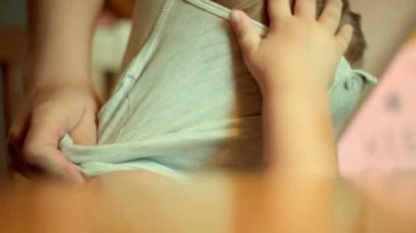 Anne çok güzel bir bebek portre Giydir. Uzun saçlı çocuk esnemek sabah esner. Çocuk uyanır ve anaokulunda elbiseler ya da evde alıntı. Yorgun uykucu çocuk. Güzel bebek yüz. Sabah yürümeye başlayan çocuk 