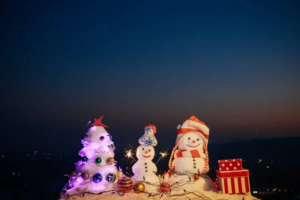 Jingle Bell muñeco de nieve en las montañas. Muñeco de nieve desea Feliz Navidad en el aire helado. Vacaciones familiares de invierno en las montañas. Noche de Navidad en las montañas. Decoraciones exteriores de Navidad — Foto de Stock